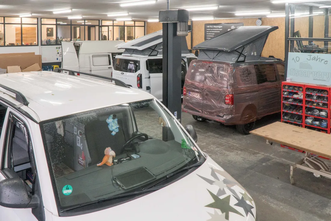 Werkstatthalle von Discarvery mit VW Bussen und Ford Tourneo Custom auf der Hebebühne
